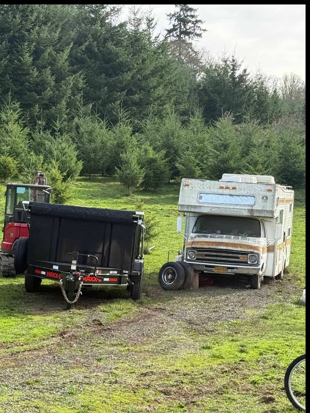 Dump trailer staged next to a derelict motorhome