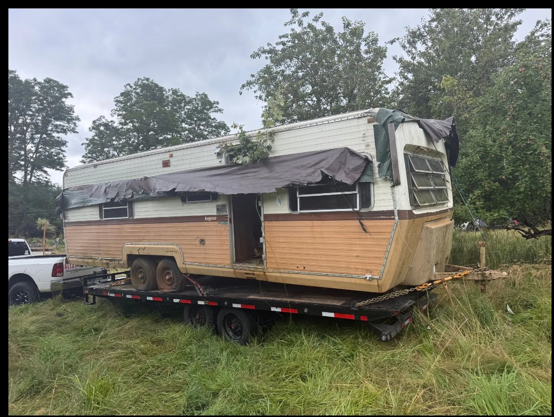 Abandoned camper pulled from a field and loaded